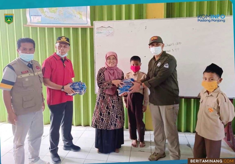 Kepala BPBD Kesbangpol Padang Panjang, I Putu Venda, S.STP, M.Si dan Kepala Dinas Pendidikan dan Kebudayaan  (Disdikbud), Nasrul, S.H, M.Si terlihat turun langsung  membagikan masker pada pelajar di sekolah-sekolah, Sabtu (13/1/2023). Foto: Kominfo Padang Panjang