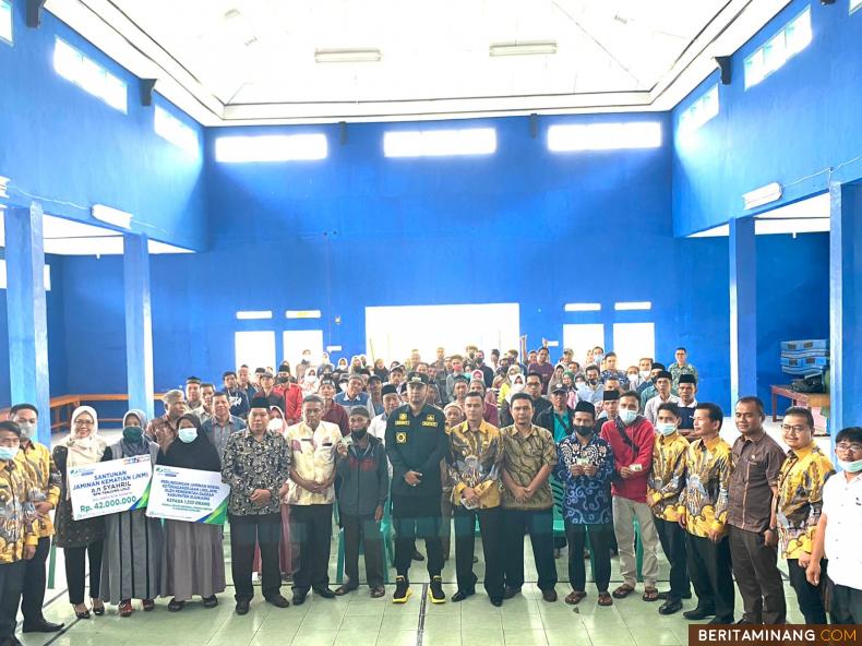 Usai menyerahkan kartu peserta BPJAMSOSTEK, Bupati Sijunjung Benny Dwifa Yuswir, Kepala BPJAMSOSTEK Cabang Solok, Ferama Putri, dan para penerima kartu melakukan foto bersama, Kamis (28/4/2022). Ist.