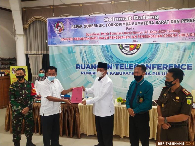 Asisten Admimistrasi Umum dan Kesra, Sekretariat Daerah Pemprov Sumbar, Drs Nasir Ahmad serahkan Perda AKB ke Bupati Limapuluh Kota Irfendi Arbi.