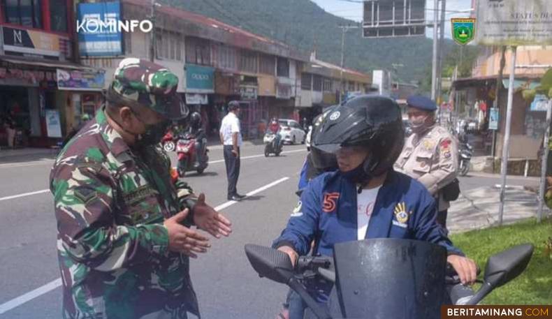 Seorang petugas TNI sedang memberikan pengarahan pada pengendara yang berboncengan di Kota Padang Panjang.