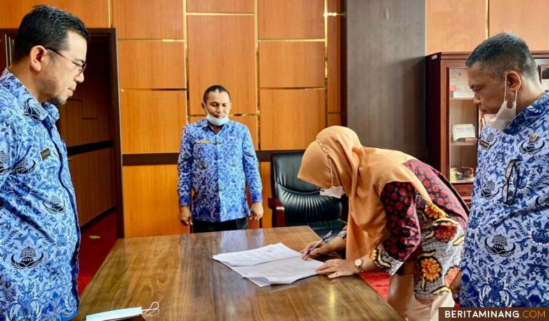 Pimpinan BPJS Ketenagakerjaan Cabang Solok, Ferama Putri disaksikan Sekretaris Daerah Kabupaten Sijunjung Zefnihan, Kadis Ketenaga kerjaan dan Transmigrasi Kabupaten, membubuhkan tanda tangan. Dok