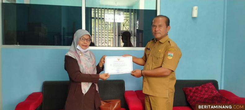 Kadis Perpustakaan dan Arsip Solsel. Yulasri. M. Si saat menyerahkan piagam perpustaan yang Akreditasi B pada Kepsek SMA Negeri 7 Solsel, Lili Suryani. S. Pd. Afrizal. A