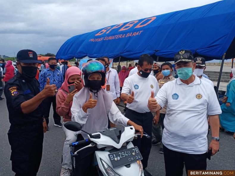 Wagub Nasrul Abit berpose dengan warga yang diberikan masker di kawasan Pantai Padang. Foto Humas Sumbar