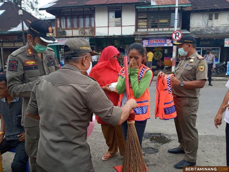 Salah seorang warga yang tidak kenakan masker di Pasar Simabur Tanah Datar menjalani hukuman kerja sosial. Foto: jurnalsumbar.com