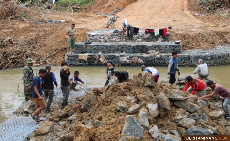 Babinsa dan Warga Binaannya bantu gotong-royong pembuatan jembatan Satgas TMMD ke-113 Kodim 0310/SS penghubung dua Nagari yakni Nagari Abai Siat dan Nagari Bonjol, Kecamatan Koto Besar, Kabupaten Dharmasraya, Kamis (26/05/22).