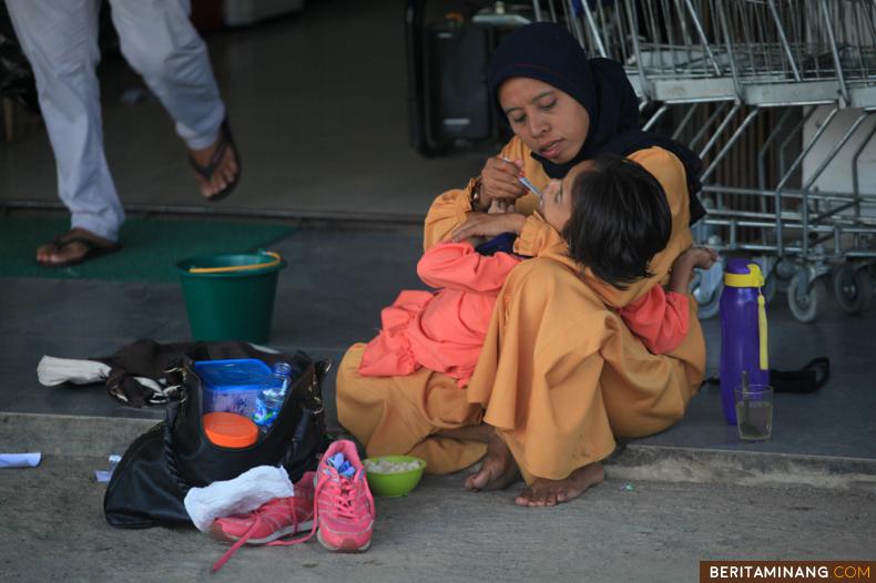 Aurel (12) warga tidak mampu dan disabilitas <em>Cerebral Palsy</em> (disabilitas fisik yang memengaruhi gerakan dan postur tubuh) dibantu makan oleh ibunya di Batusangkar, Kabupaten Tanah Datar, Sumatra Barat, Sabtu (27/06/2020). Data BPJS Kesehatan per Mei 2020 dari total 220,6 juta peserta JKN KIS, 130,1 juta warga Indonesia yang tergolong fakir miskin dan orang tidak mampu merupakan Peserta Penerima Bantuan Iuran Jaminan Kesehatan (PBI JK) yang iurannya dibayarkan pemerintah dengan sumber bantuannya dari APBD dan APBN. (Beritaminang/Adi Prima).