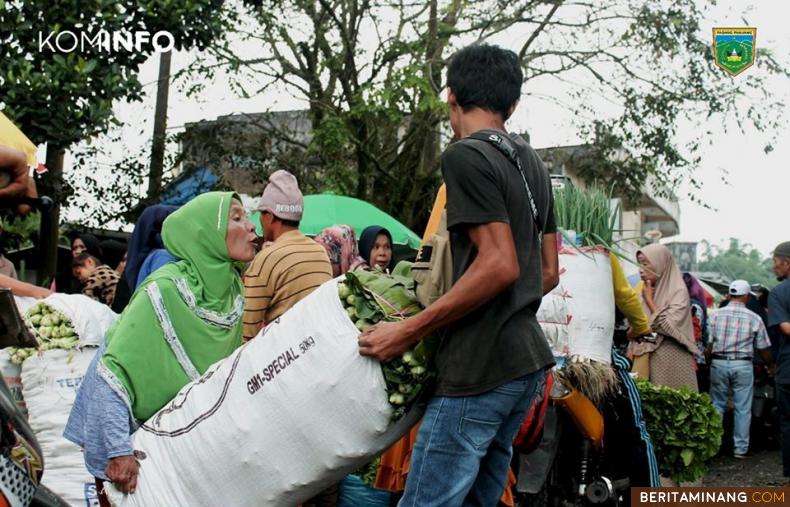 PEDAGANG DAN AKTIVITAS PASAR SAYUR - Seorang pedagang sedang mengangkat sayuran di Pasar Sayur yang berada di Terminal Bukit Surungan, Padang Panjang Barat, Kota Padang Panjang. Pasar ini terlihat ramai dengan aktivitas jual beli hasil pertanian, perkebunan, dan perternakan pada waktu Pagi hingga sore hari, Kamis (06/02/2020). Di Pasar ini, tersedia sayuran - sayuran segar seperti, buncis, seledri, wortel, daun bawang (Bawang Perai), Labu siam (Japan), tomat, kentang, kol, cabai merah, cabai hijau (Lado Merah dan Lado Hijau) dan bahan dapur lainnya. Foto: Kominfo Padang Panjang