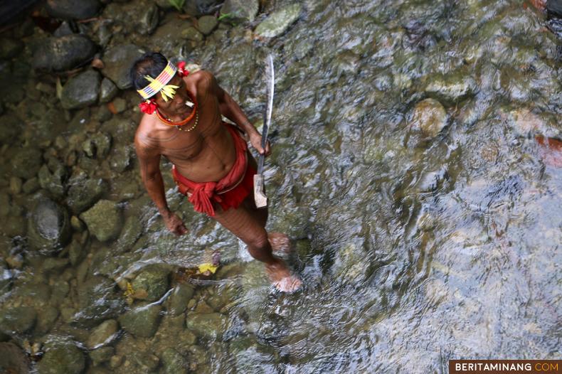 Sikerei (paramedis tradisional Mentawai) melintas di sungai di Dusun Kulukubuk, Desa Madobag, Siberut Selatan, Kabupaten Kepulauan Mentawai, Sumbar, Jumat (26/8/2022). Pulau Siberut di Kepulauan Mentawai merupakan tempat tinggal Sikerei masyarakat asli Mentawai. (Beritaminang/AP).