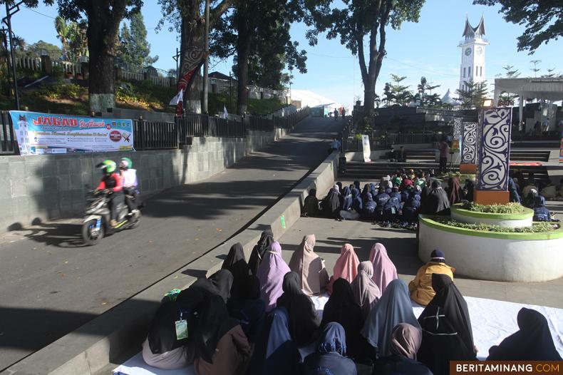 Peserta membaca Al-Quran pada acara Tilawah Al-Quran di kawasan pedestrian Jam Gadang, Bukittinggi, Sumbar, Minggu (10/4/2022). Gerakan tilawah mengkhatamkan Al-Quran kembali digelar setelah dua tahun ditiadakan karena pandemi. (Beritaminang/AP).