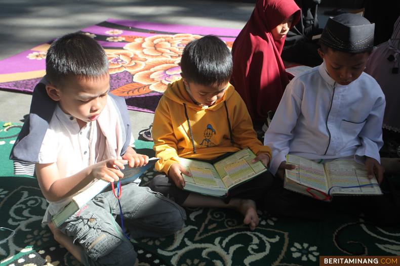 Peserta anak-anak membaca Al-Quran pada acara Tilawah Al-Quran di kawasan pedestrian Jam Gadang, Bukittinggi, Sumbar, Minggu (10/4/2022). Gerakan tilawah mengkhatamkan Al-Quran kembali digelar setelah dua tahun ditiadakan karena pandemi. (Beritaminang/AP).